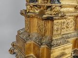 a gold clock with a statue on top of it
