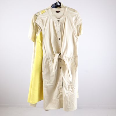 yellow and white dress hanging on a hanger in a white room