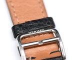 black and tan leather strap with silver buckle on white background