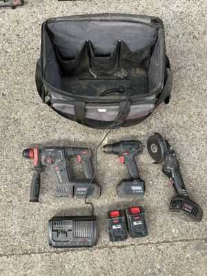 des outils disposés par terre dans un sac posé par terre