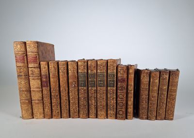several old books are stacked on top of each other on a white surface