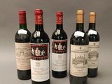 four bottles of wine are lined up in a row on a gray surface