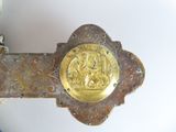 a metal cross with a gold medallion on it