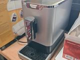 a coffee machine sitting on a table next to a laptop