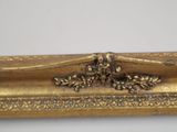 a close up of a gold frame with a bird on it