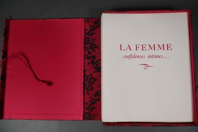 un livre ouvert, à la couverture rouge, posé sur une table