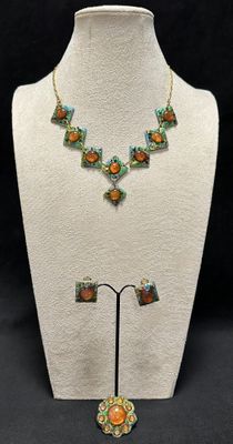 a close up of a necklace and earrings on a mannequin