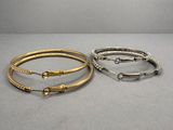 deux bracelets en or et en argent sur un fond gris