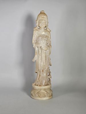 une statue blanche représentant une femme tenant un bébé dans ses bras