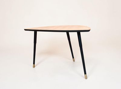 une image représentant une table en bois aux pieds noirs sur fond blanc