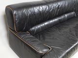 a black leather couch and a black chair on a white background