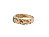 an image of a gold ring with a green stone in the middle
