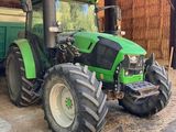 un tracteur vert garé dans une grange
