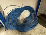 a bunch of blue wires sitting on the ground next to a wall