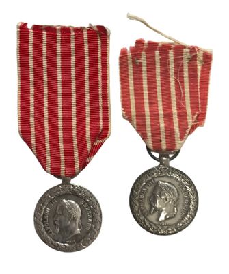 deux médailles ornées d'un ruban rouge et une médaille d'argent sur fond blanc