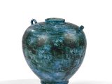 un vase bleu posé sur une surface blanche