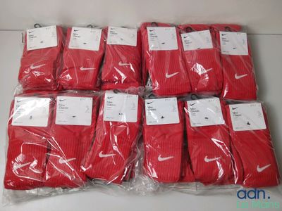 six paires de chaussettes rouges sont emballées dans des sacs en plastique sur une table