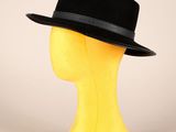 tête de mannequin jaune coiffée d'un chapeau noir