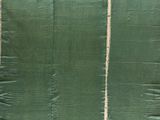 une image montrant un morceau de tissu vert en train d'être cousu