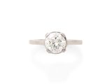 une bague en or blanc sertie d'un diamant rond taille brillant