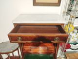 a small wooden table with a marble top and two stools