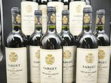 six bouteilles de vin rouge sont alignées sur une table