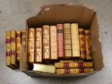 une boîte en carton remplie de vieux livres, posée par terre