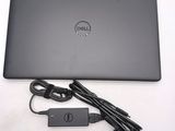 dell laptop computer with power cord and charger sitting on a white surface