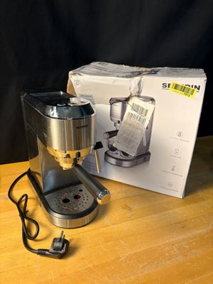 une cafetière posée sur une table à côté d'une boîte