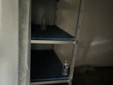 a shelf in the corner of a room with a can of soda on it