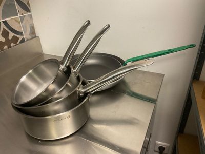 des casseroles et des poêles posées sur une cuisinière dans une cuisine