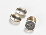 two silver spoons with a tree on them sitting on top of a white surface