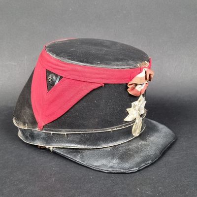 un chapeau noir orné d'un ruban rouge et d'une étoile