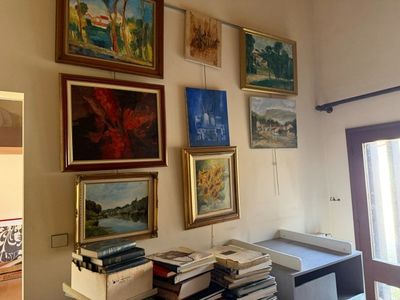 de nombreux tableaux accrochés au mur au-dessus d'un bureau dans une pièce