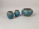 three blue vases sitting next to each other on a white surface