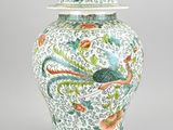 an image of a white and green vase with a bird on it