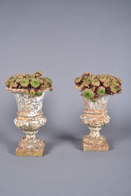 pair of vases with flowers in them on a gray surface