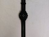 the watch is sitting on a white surface next to a white wall
