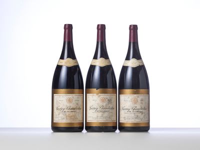 three bottles of wine are lined up on a table