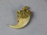 a gold pendant with an elephant ' s tusk on it