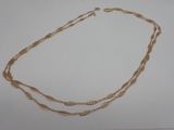 gros plan d'un collier en or sur une surface blanche