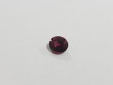 a red garnet stone on a white surface