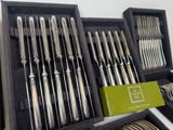 many different types of silverware in a display case