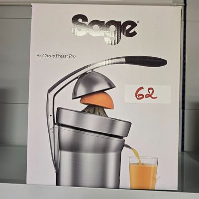 une boîte contenant un presse-agrumes et un verre de jus d'orange