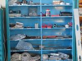 a blue bookcase filled with assorted items in a garage