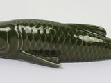 a green fish shaped keychain on a white surface