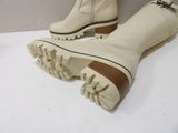pair of white boots with brown soles on a white surface