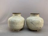 two white vases sitting next to each other on a table