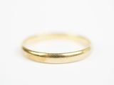 gros plan d'une bague en or sur une surface blanche