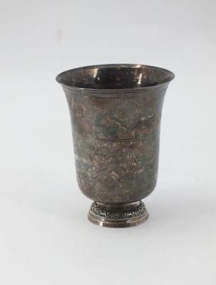 a silver cup that is sitting on a white surface